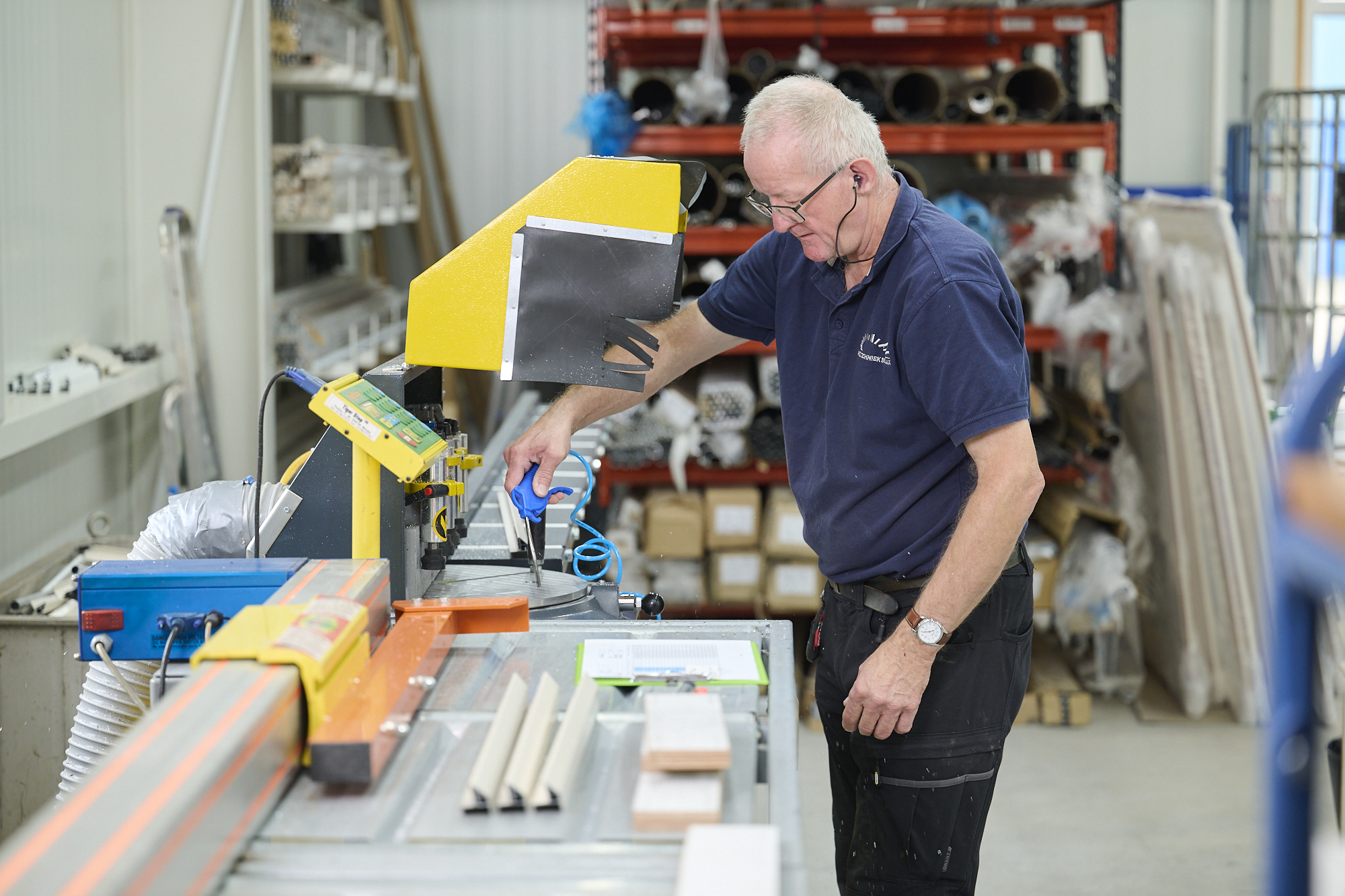 Werknemer bij de zaagbank in de werkplaats van Rol Techniek Benelux.