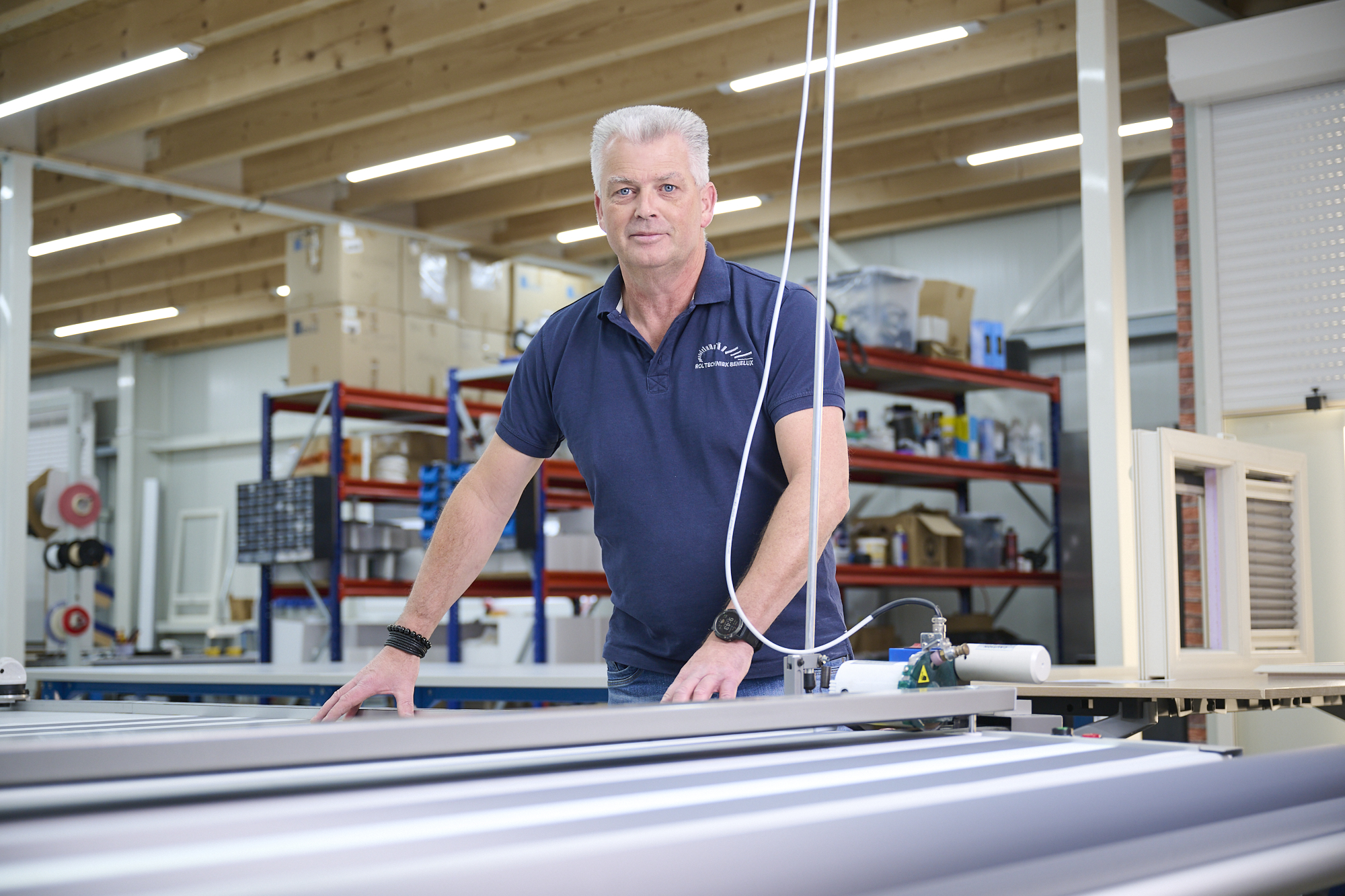 Werknemer in werkruimte met rolgordijn van Rol Techniek Benelux.